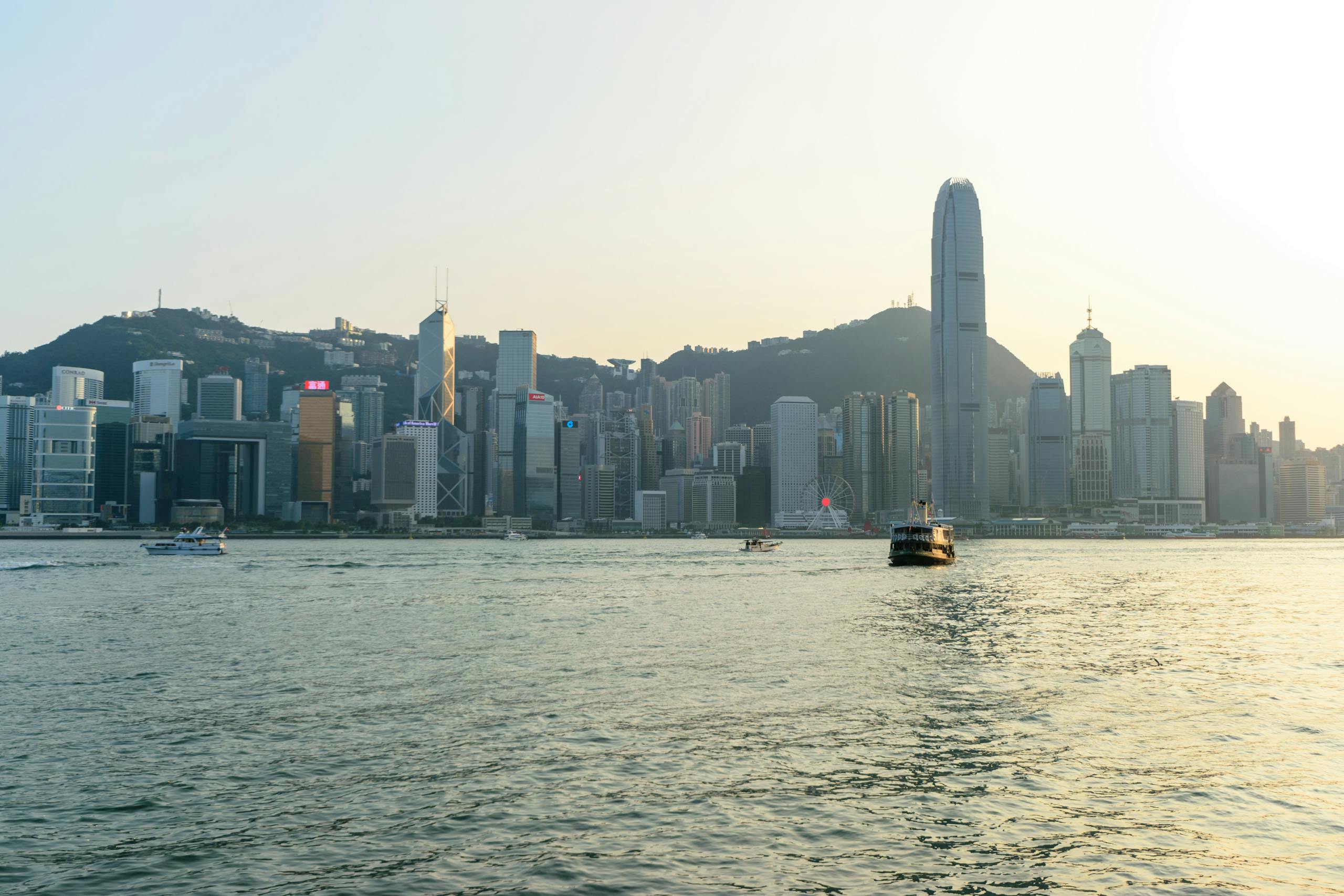 Serene view of Hong Kong's skyline and Victoria Harbour at sunset.